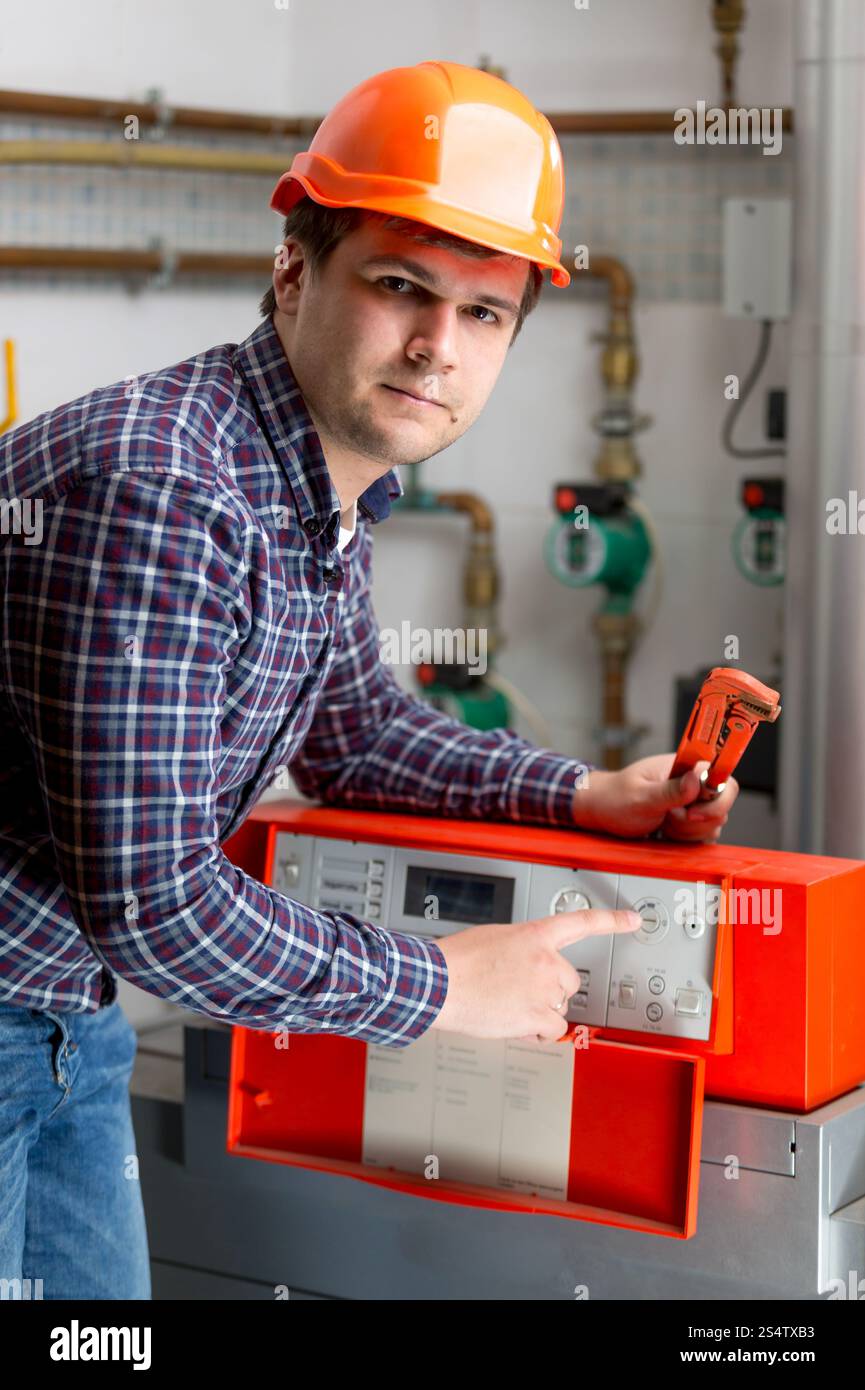 Ritratto di ingegnere di regolazione riscaldamento sul lavoro il controllo automatizzato cruscotto Foto Stock