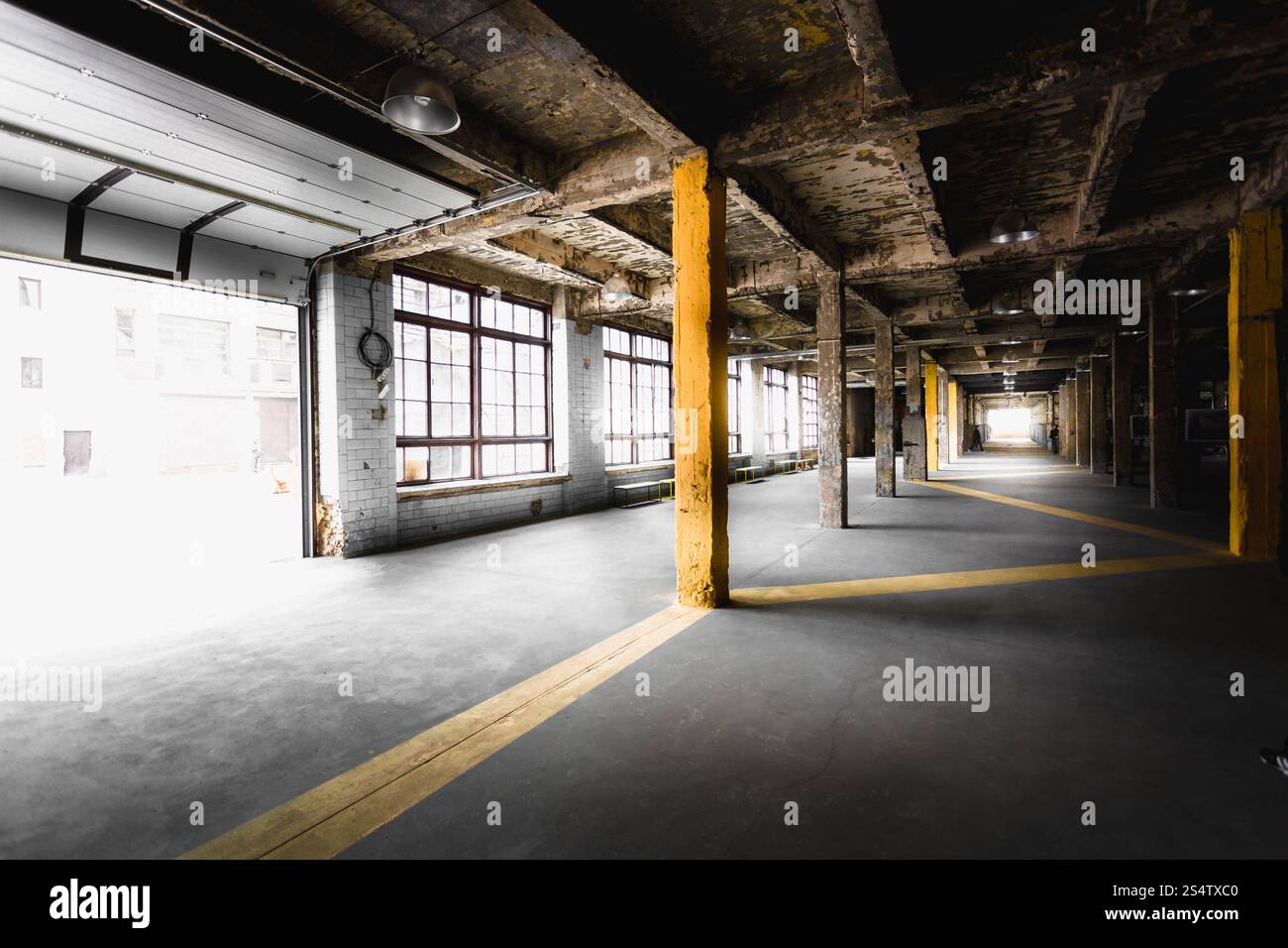 Interno della vecchia fabbrica abbandonata in corridoio con grandi finestre Foto Stock