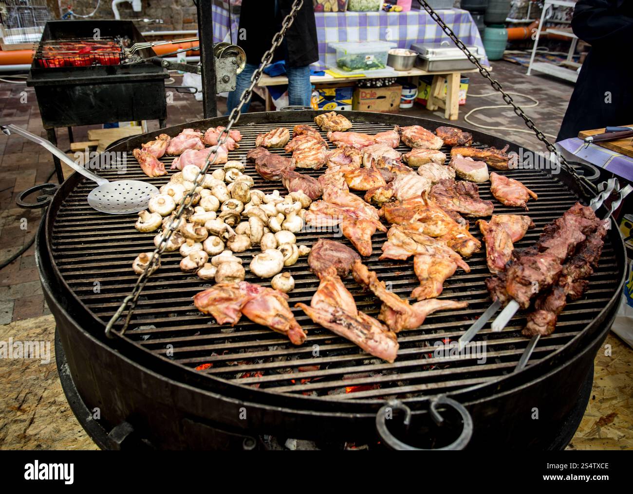 Le carni ed i funghi per la cottura sul grande barbecue a cucina esterna Foto Stock