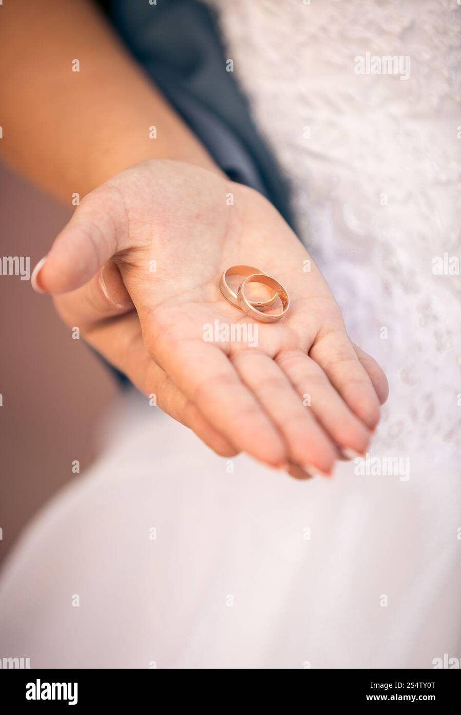Foto ravvicinata di una bellissima sposa che tiene a portata di mano la fede nuziale Foto Stock