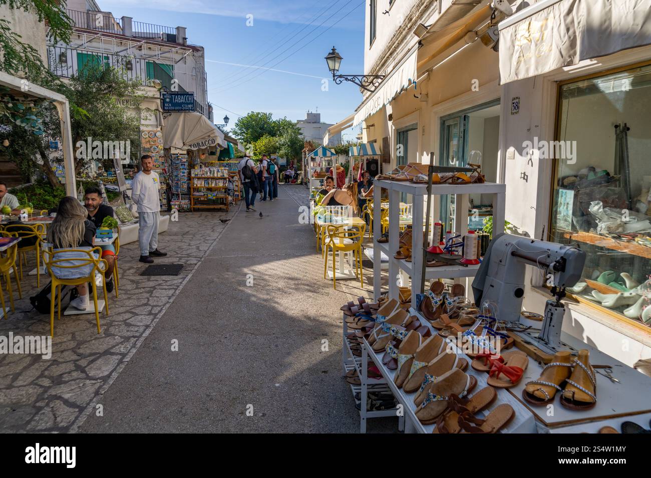 I visitatori cenano all'aperto in una strada di negozi ad Anacapri, sull'isola di Capri, Italia. Foto Stock