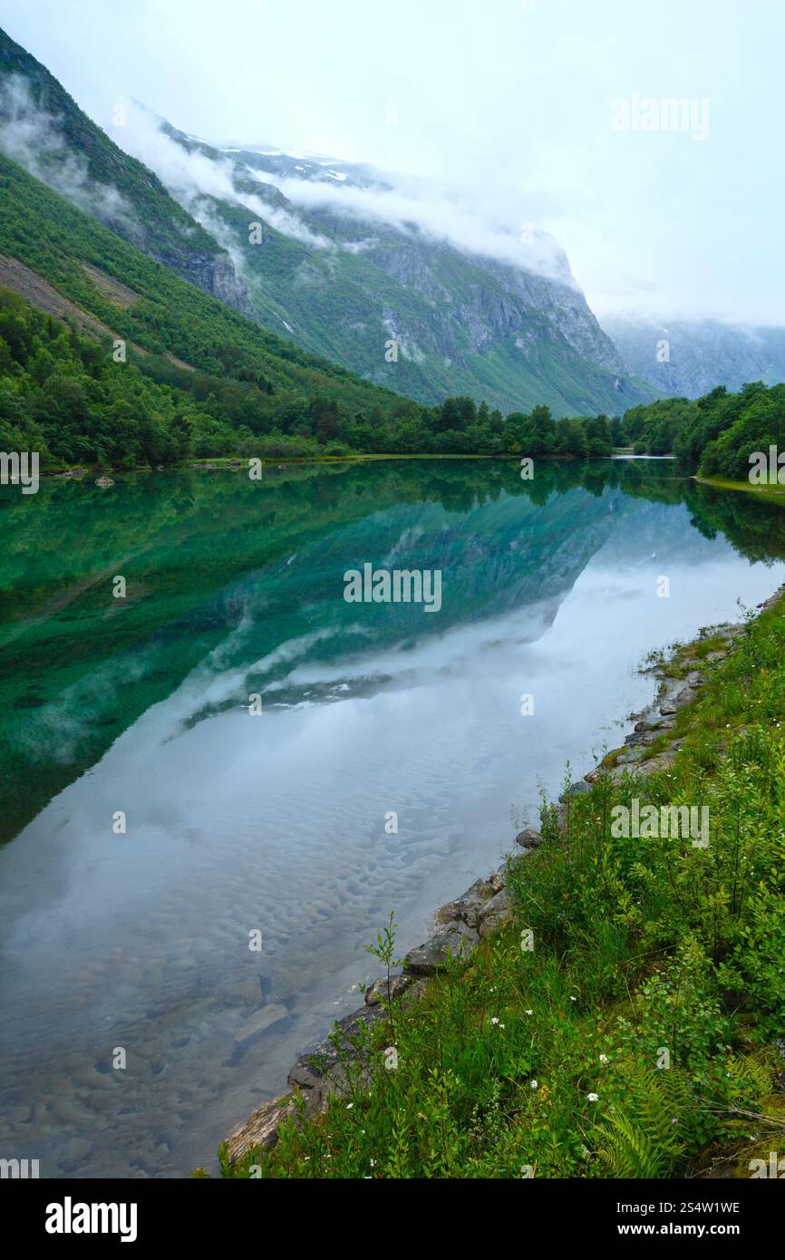 Lago di montagna con acqua pulita e montagne riflessa (Norvegia, vicino Stordal). Estate nuvoloso vista. Foto Stock