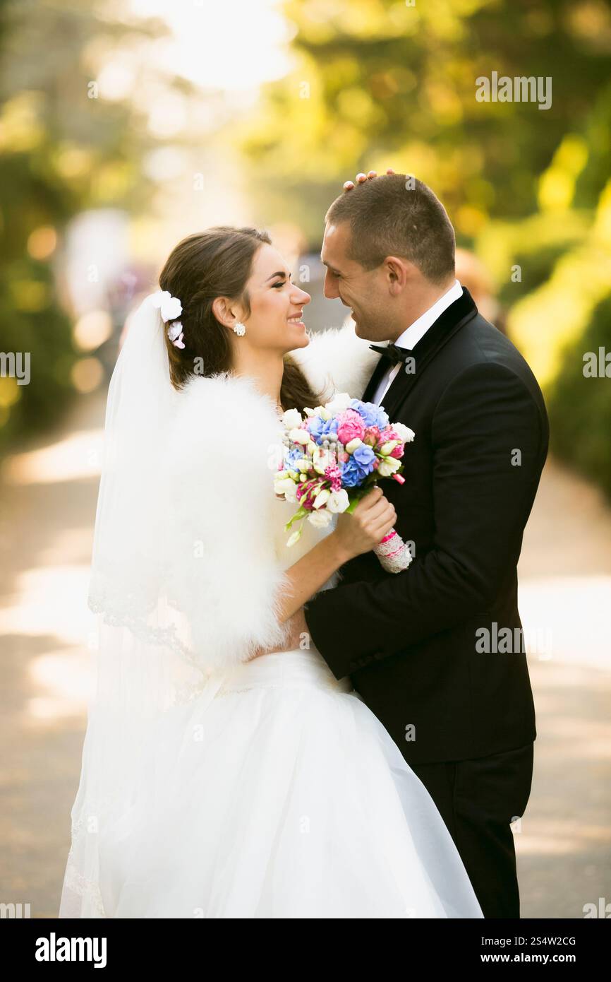 Ritratto ravvicinato della sposa e dello sposo felice sorridente che si guardano l'un l'altro nel parco autunnale Foto Stock