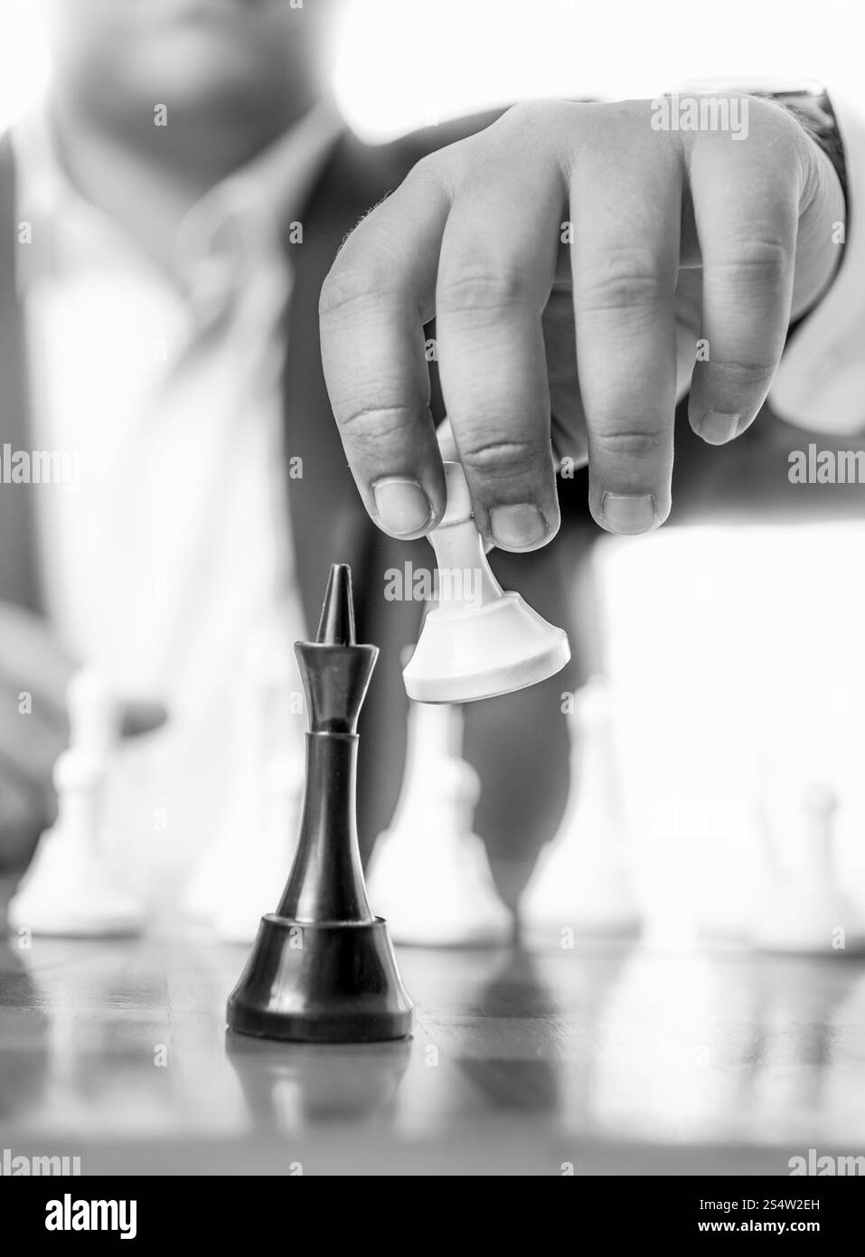 Bianco e nero closeup foto di imprenditore battendo il re di scacchi con pegno Foto Stock