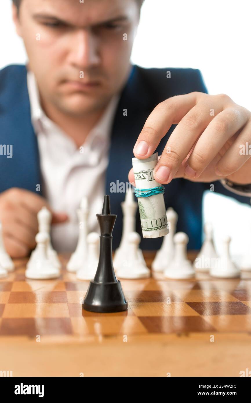 Inquadratura concettuale della potenza di denaro. Uomo che fa spostare di scacchi con banconote di dollari Foto Stock