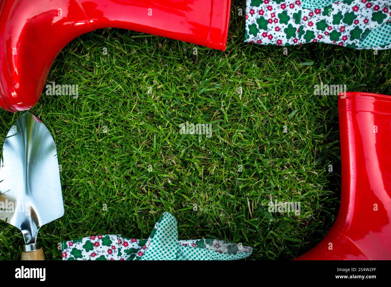 Bella cornice fatta di attrezzi da giardino giacente sulla fresca erba verde Foto Stock