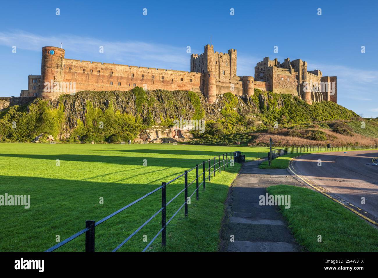 Castello di Bamburgh al sole mattutino d'inverno, Northumberland AONB, Inghilterra Foto Stock
