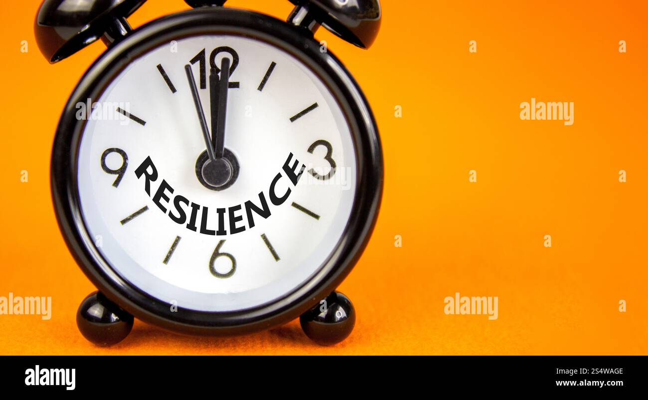 Simbolo di resilienza. Concetto di resilienza su una bella carta arancione. Splendido sfondo arancione. Sveglia nera. Cep. Resilienza aziendale Foto Stock