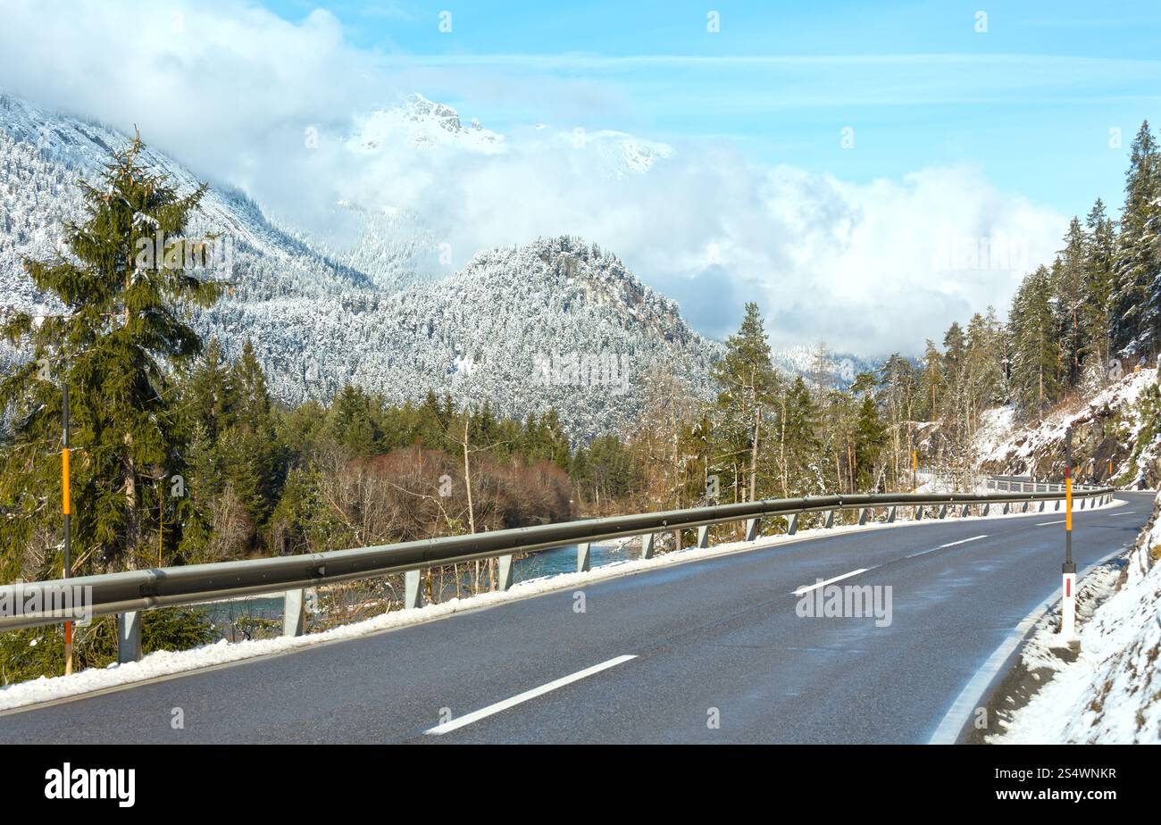 La strada lungo il fiume e coperto di neve e piste di montagna (Austria, Tirolo). Foto Stock