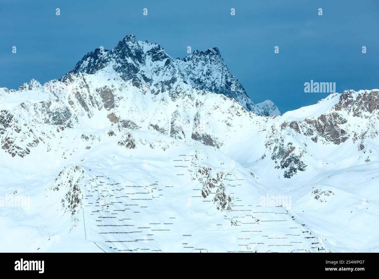 Inverno mattutino Alpi Silvretta (Austria) paesaggio e scherma contro lo scivolamento della neve in pendenza. Foto Stock Inverno mattutino Alpi Silvretta (Austria) paesaggio e scherma contro lo scivolamento della neve in pendenza. Foto Stock