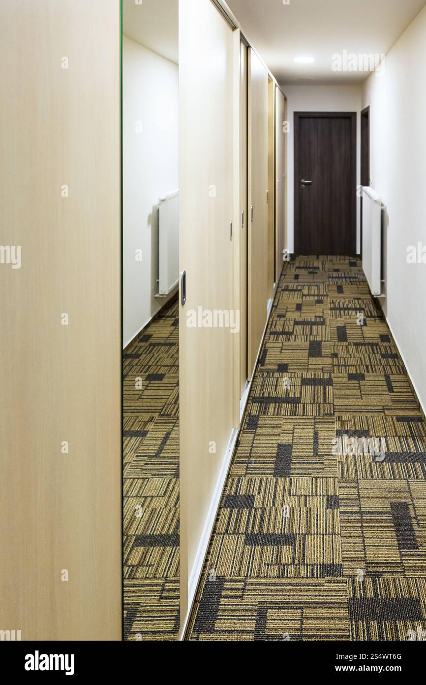 Stretto corridoio con built-in mobili con specchio della porta Foto Stock