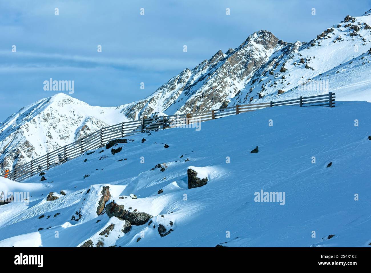 Mattina inverno vista montagna con staccionata in legno sulla collina (Tirolo, Austria). Foto Stock