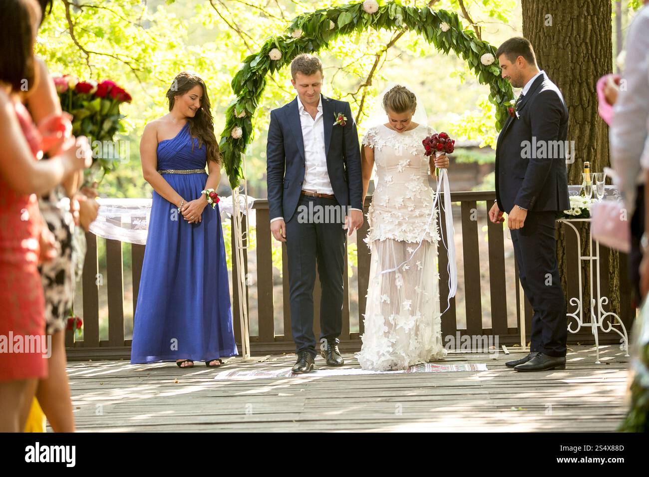 Gli sposi novelli si godono una cerimonia di nozze all'aperto nella foresta Foto Stock