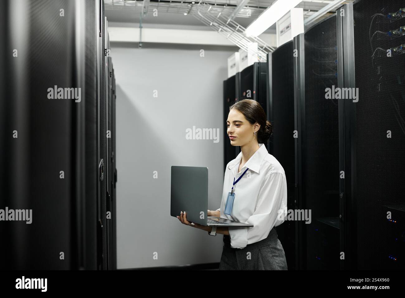 Uno specialista IT dedicato in una camicia bianca gestisce i sistemi informatici in un data center. Foto Stock