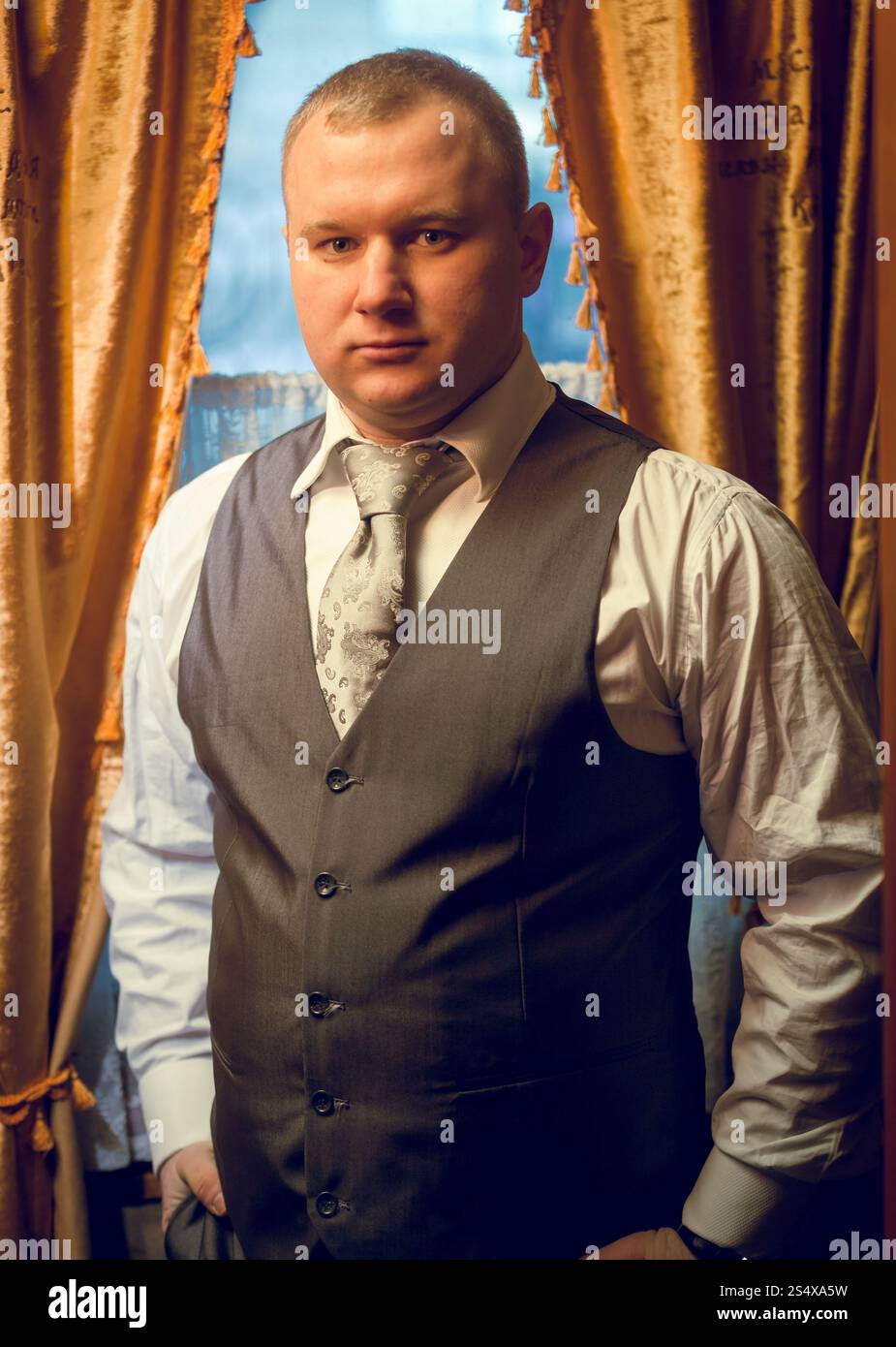 Tonica ritratto di imprenditore fiducioso nella posa in corrispondenza della finestra Foto Stock