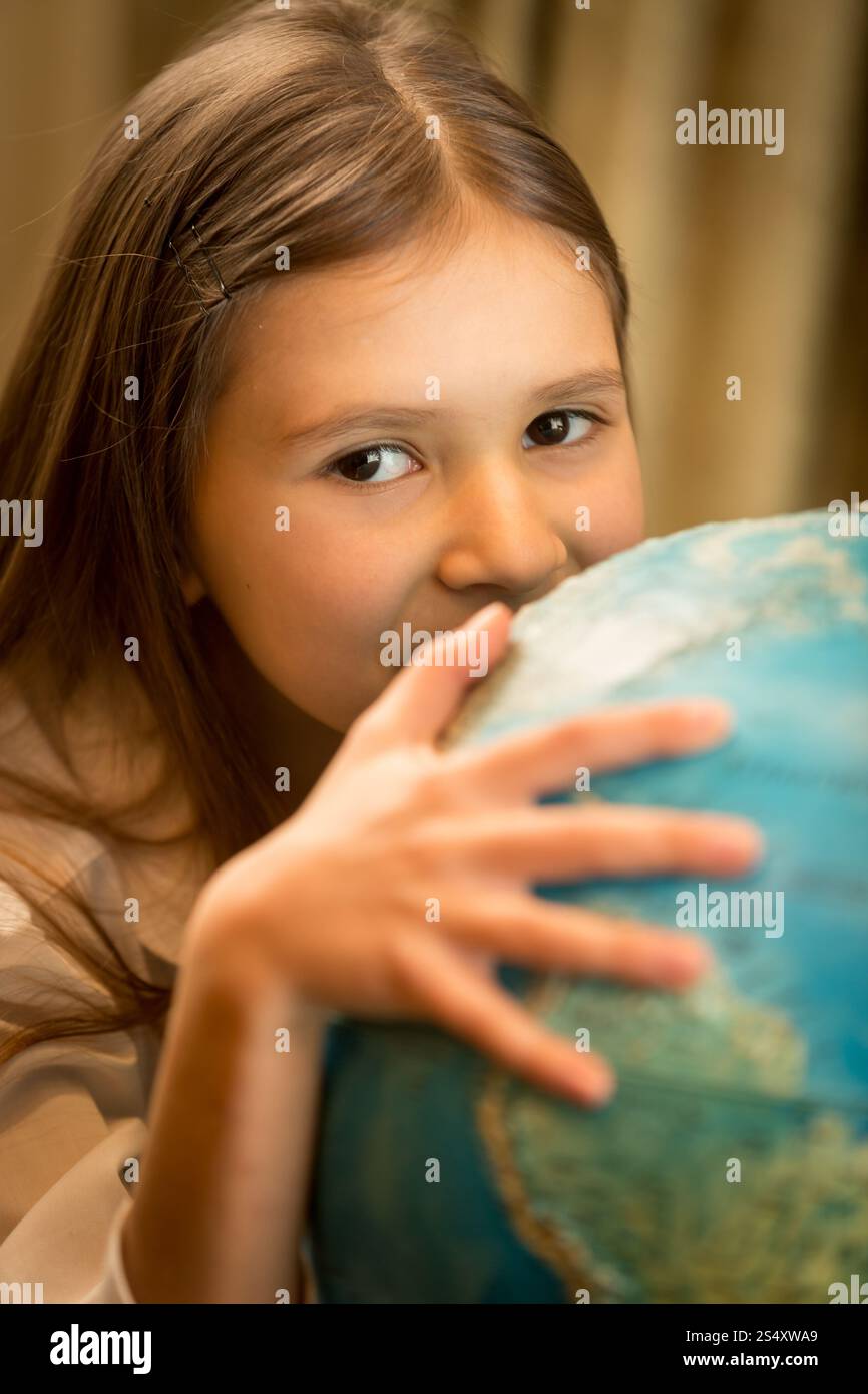 Closeup ritratto della ragazza carina tenendo la mano sul globo terrestre Foto Stock