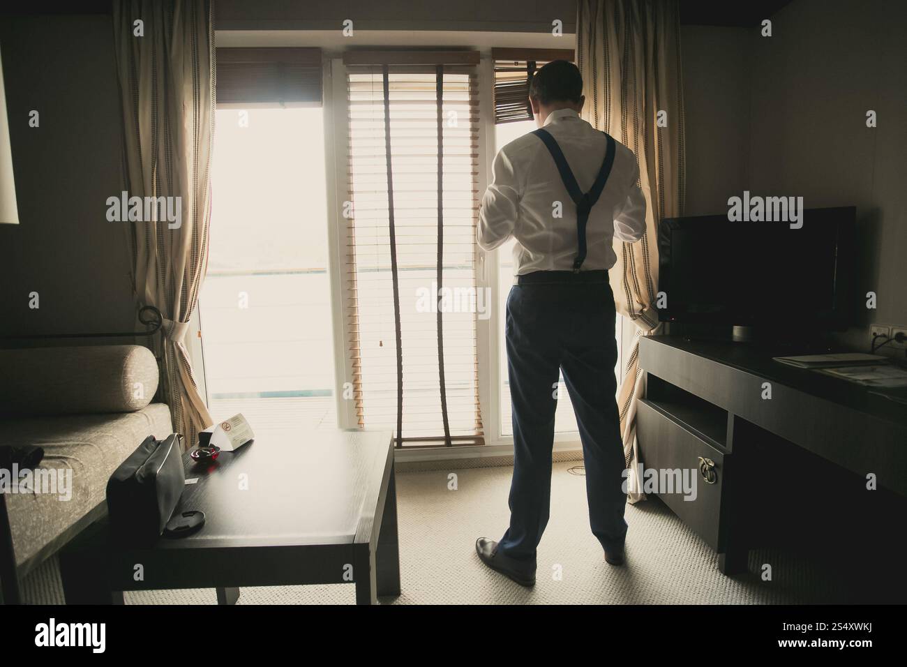 Tonica foto del giovane imprenditore medicazione fino alla camera di albergo Foto Stock