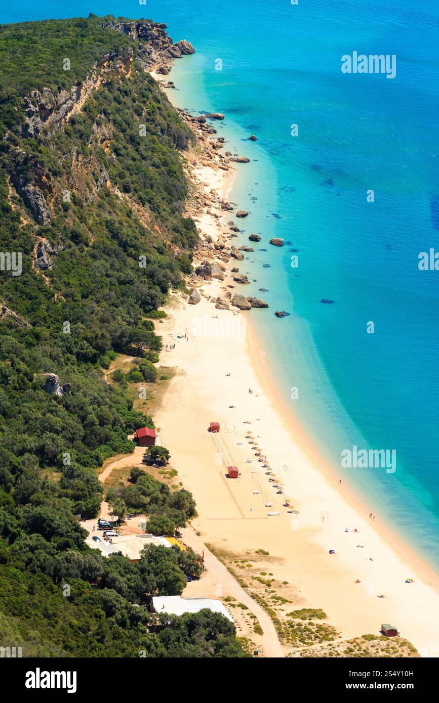 Paesaggio costiero marino estivo con spiaggia sabbiosa di Portinho. Vista dall'alto dal Parco naturale di Arrabida a Setubal, Portogallo. Tutti i popoli irriconoscibili. Foto Stock