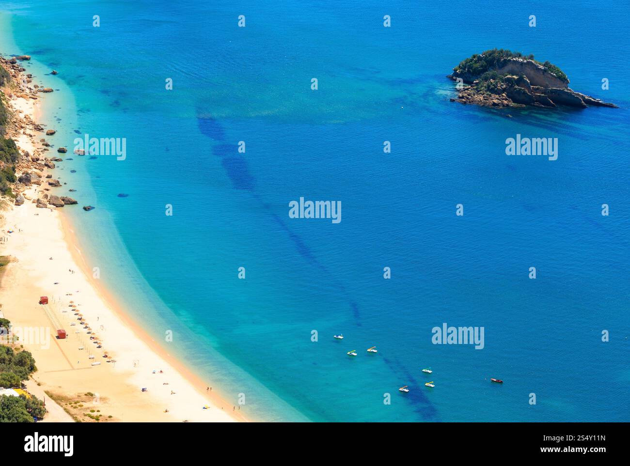 Paesaggio costiero marino estivo con spiaggia sabbiosa di Portinho. Vista dall'alto dal Parco naturale di Arrabida a Setubal, Portogallo. Tutti i popoli irriconoscibili. Foto Stock