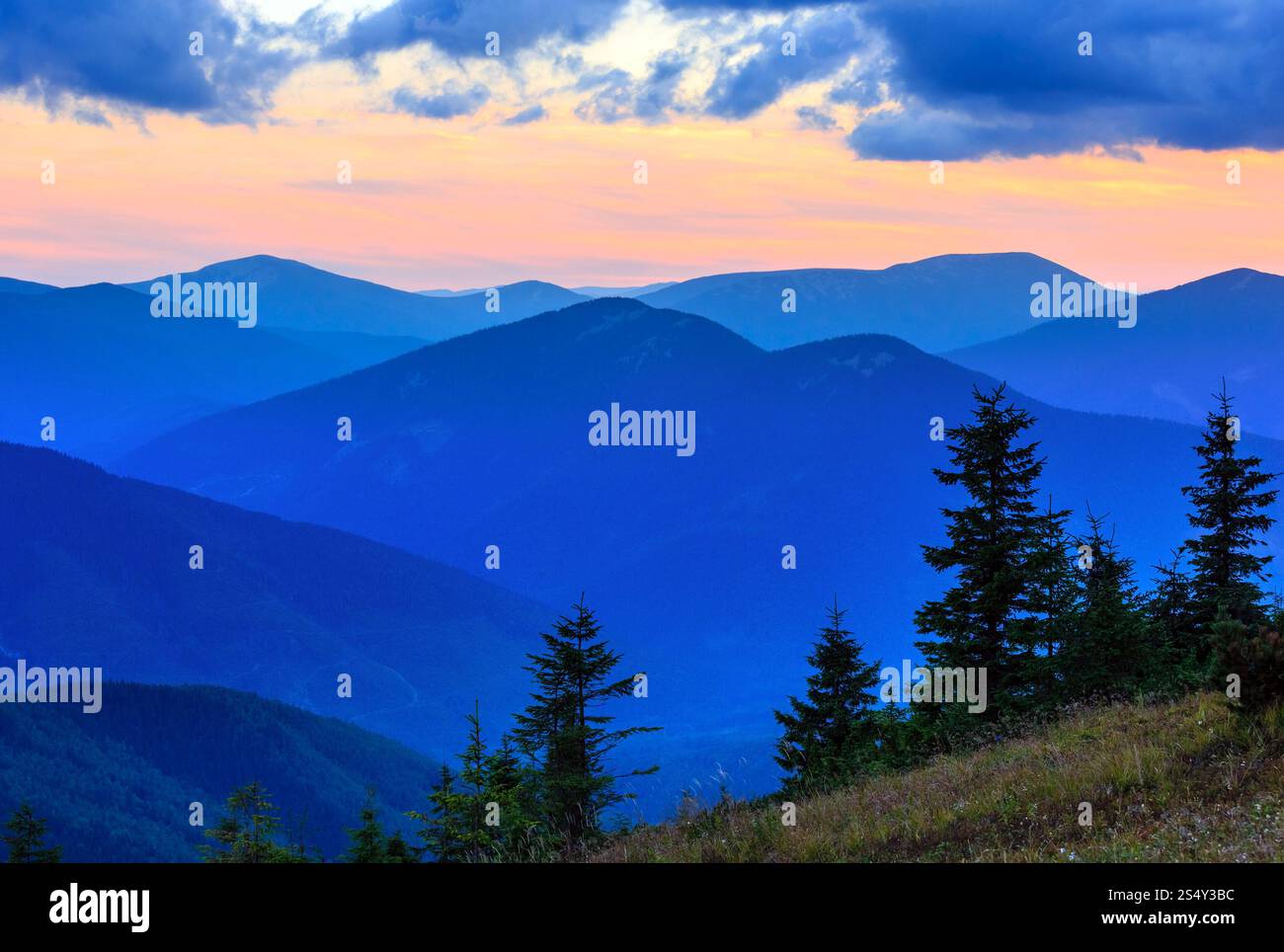 Profilo di montagna sul cielo della sera (con le nuvole) sfondo. Estate tramonto crepuscolo fine (Carpazi, Ucraina). Foto Stock