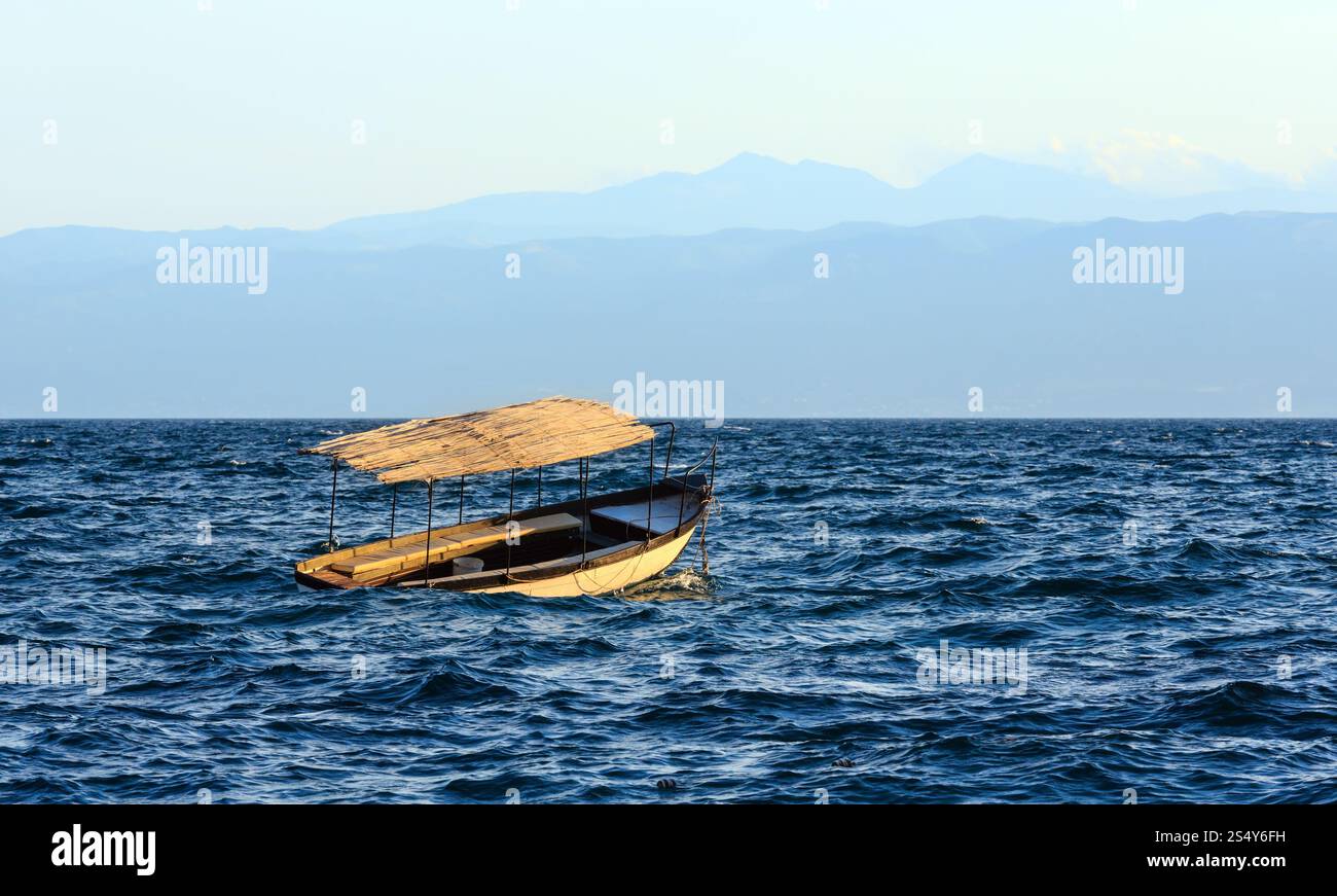 Di sera il lago di Ohrid Vista nebbiosa con la barca e le onde (Macedonia). Foto Stock