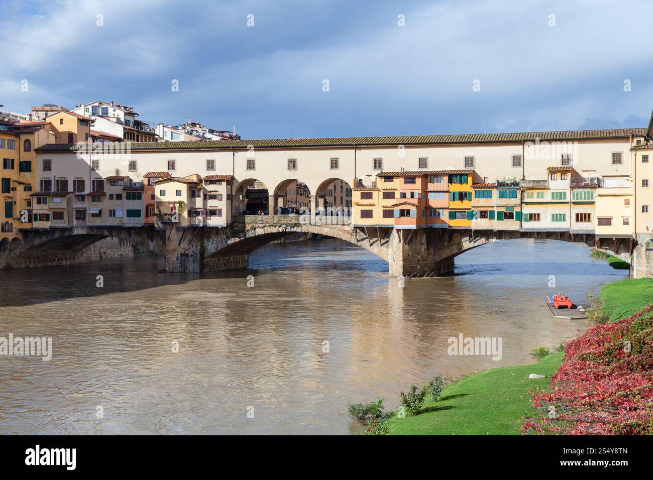 Viaggiare in Italia - vista del Ponte Vecchio sulla riva del fiume Arno a Firenze città nella soleggiata giornata autunnale Foto Stock