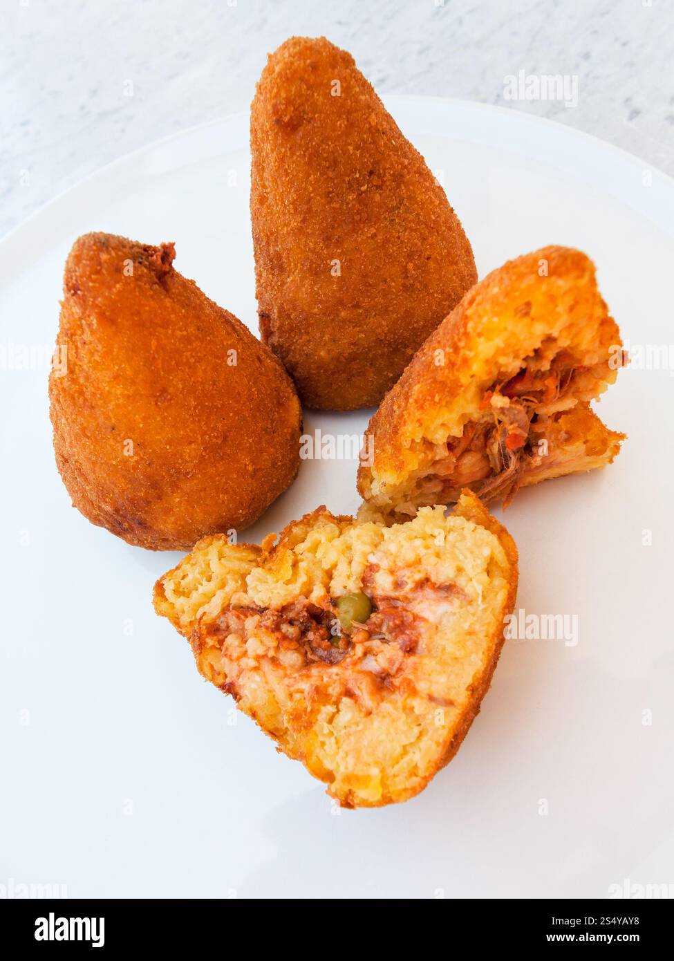 Viaggiare in Italia cucina italiana - tradizionale ( arancini di riso fritto sfere riempiti con riempimento rivestito con pangrattato) sulla piastra bianca in Sicilia Foto Stock