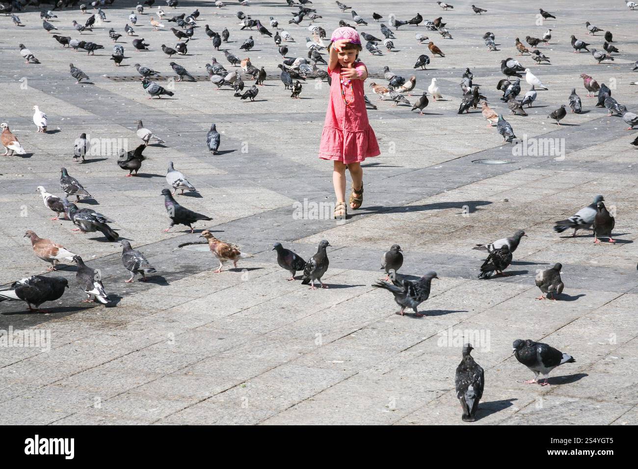 Viaggi in Grecia - ragazza a caccia di piccioni in Piazza urbana nella città di Atene Foto Stock