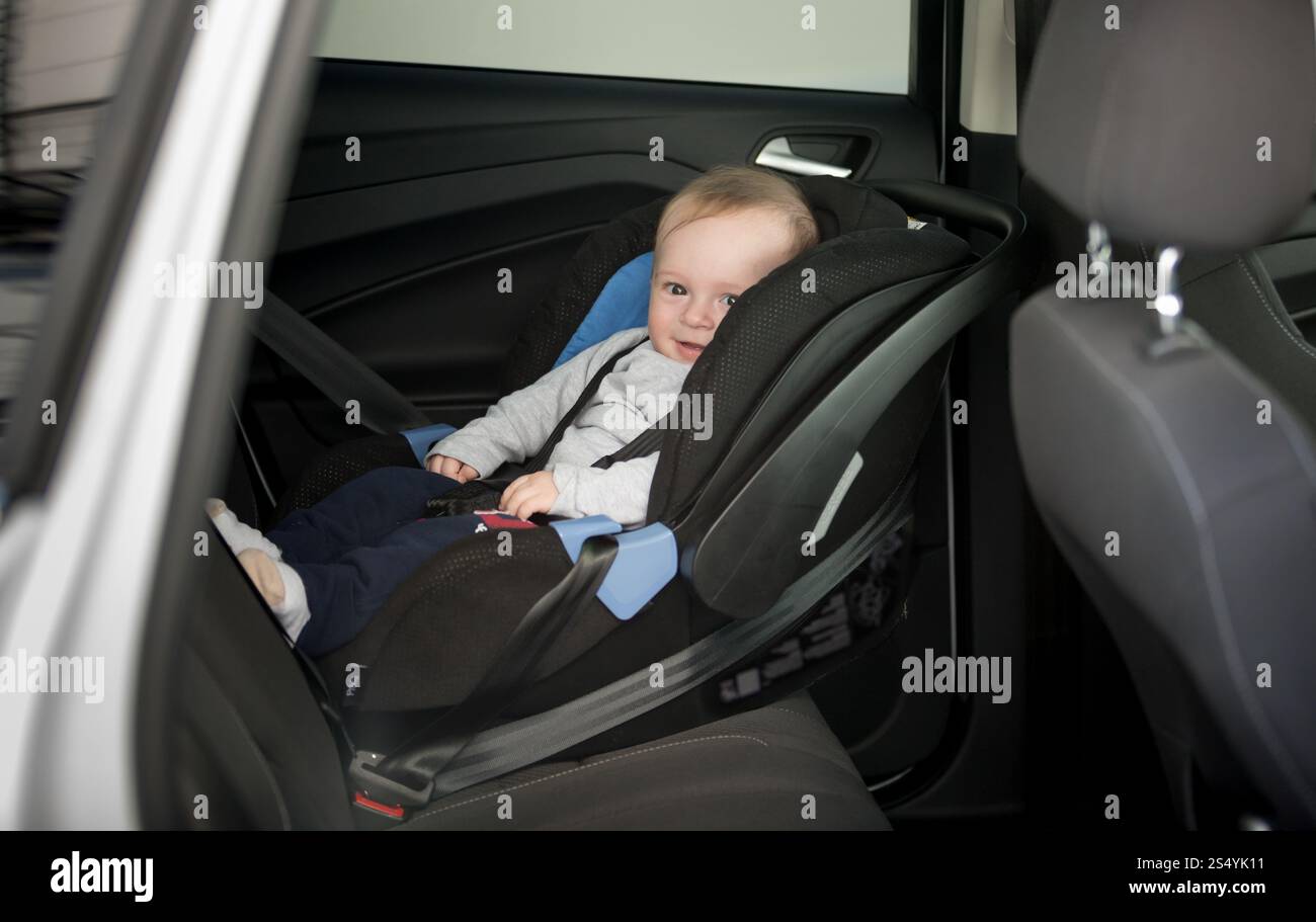 bambino di 6 mesi seduto nel seggiolino dell'auto Foto Stock