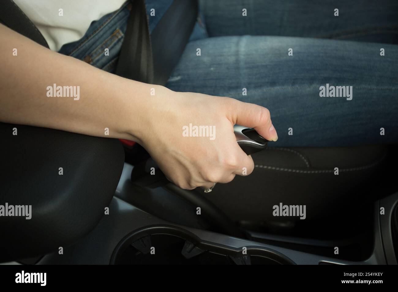Primo piano di una donna che tiene la leva del freno a mano Foto Stock