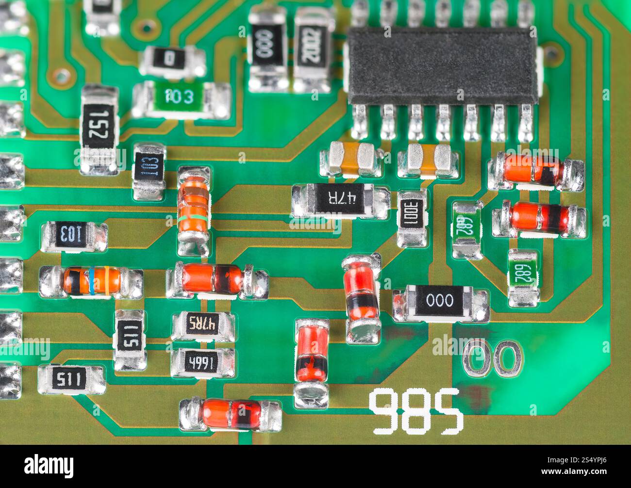 Primo piano dell'assemblaggio a montaggio superficiale di componenti elettronici su scheda a circuito stampato. Diodi Zener rossi o arancioni, microchip nero e resistenze di piccole dimensioni. Foto Stock