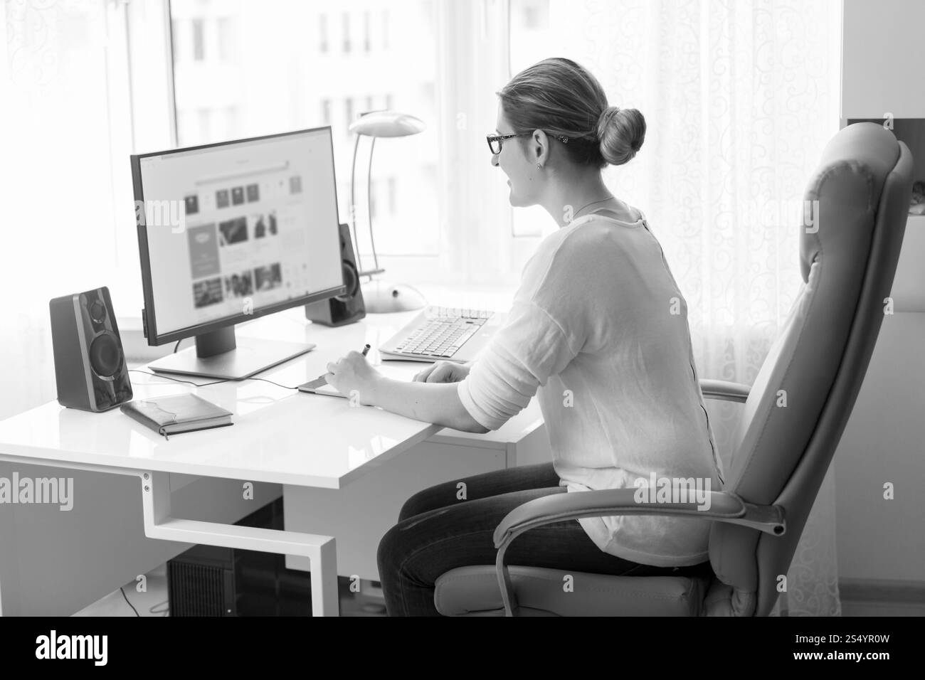 Bianco e nero ritratto della bellissima femmina designer che lavora al computer Foto Stock