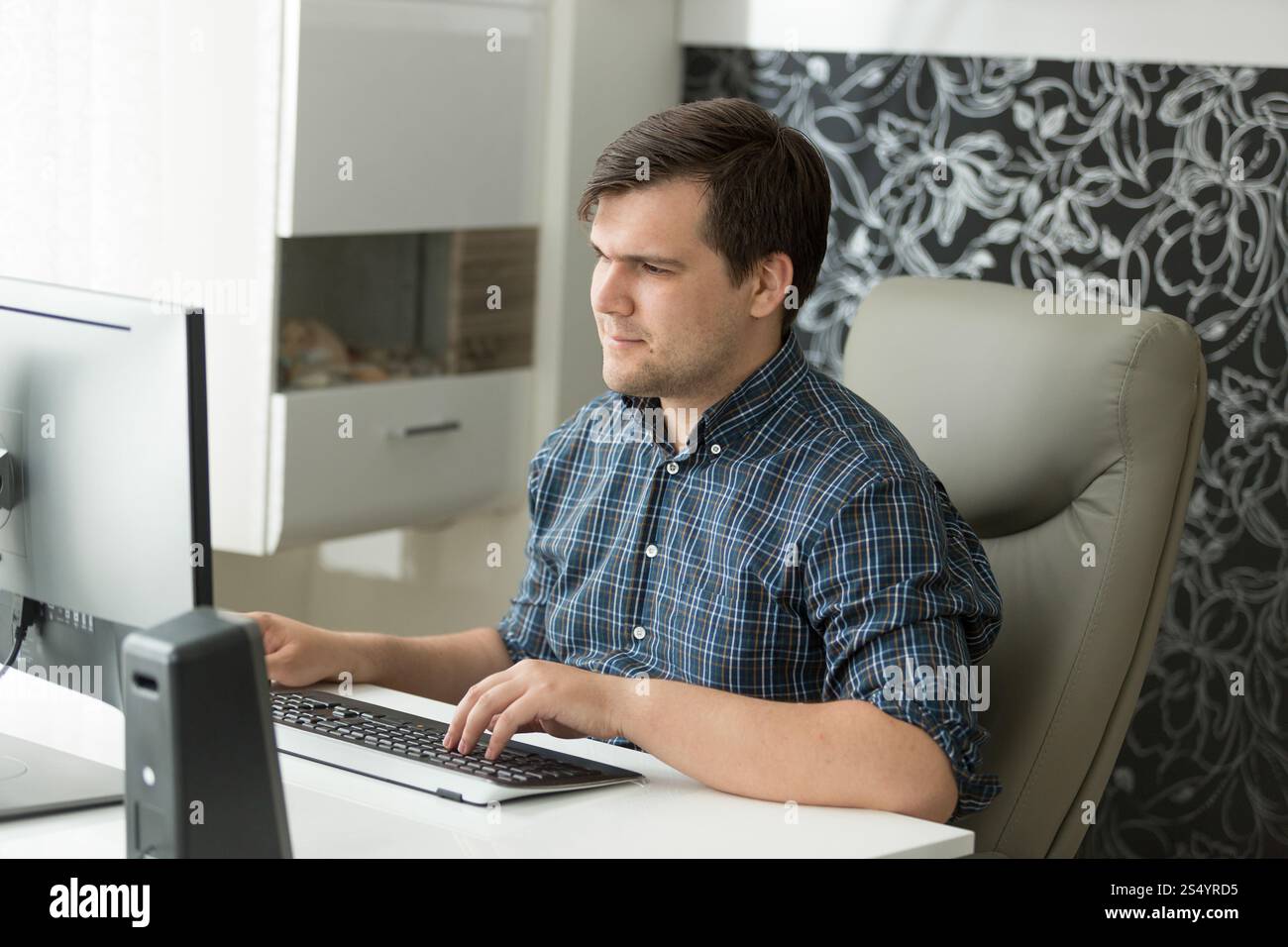 Giovane uomo in abiti casual che lavora in ufficio Foto Stock