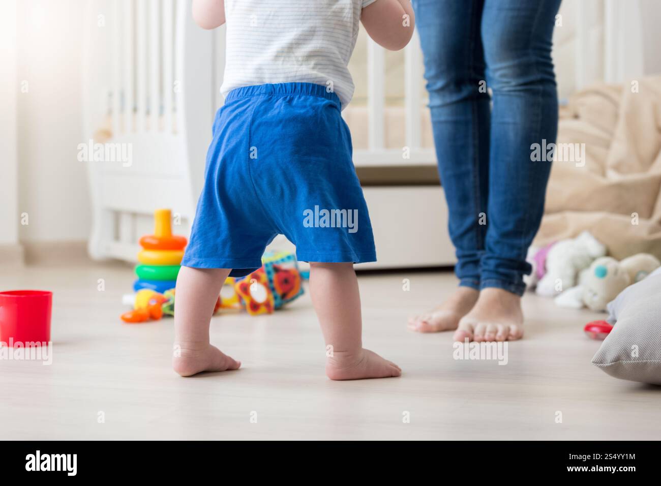 Immagine ravvicinata di un bambino di 10 mesi che fa i primi passi a casa Foto Stock