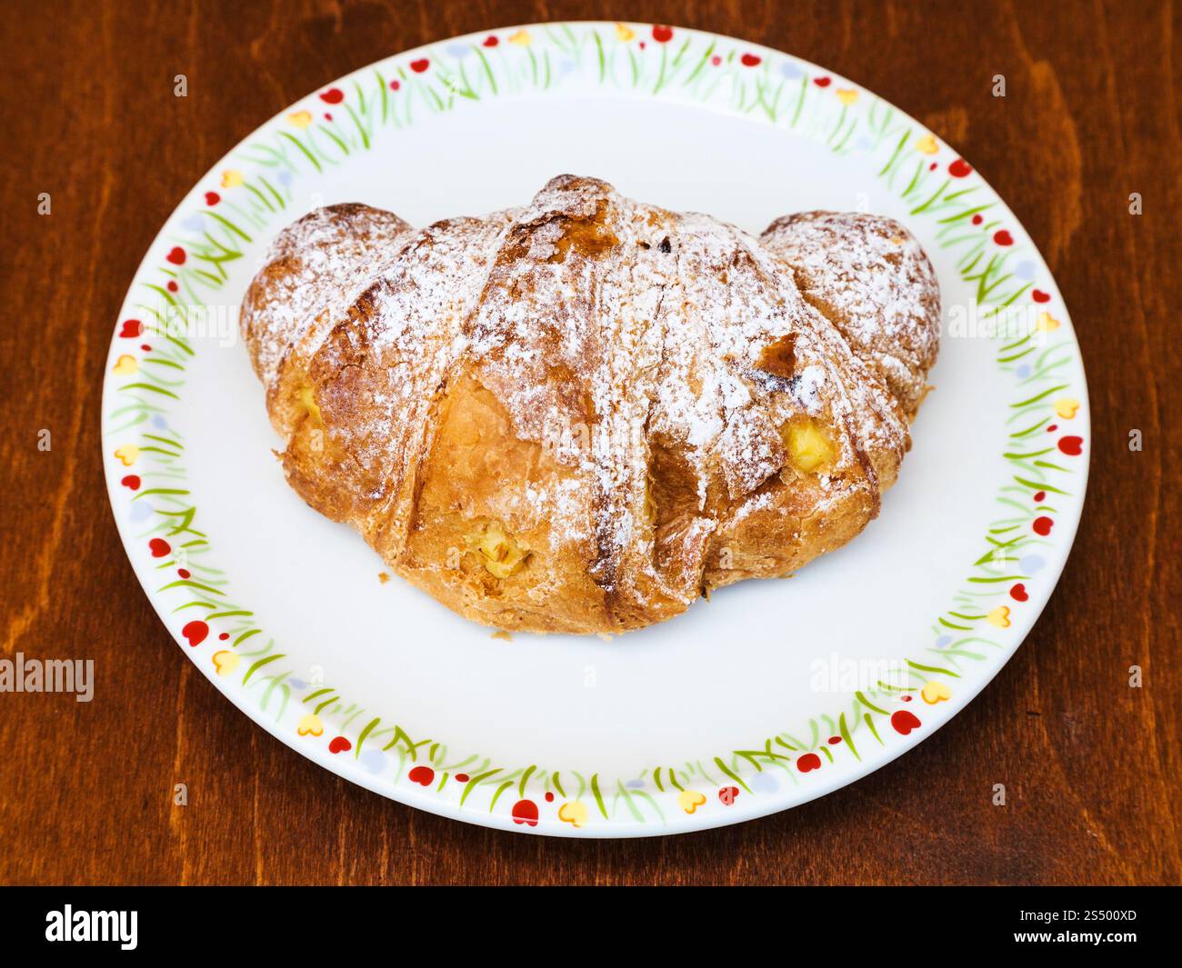 Italiani freschi croissant riempiti da crema vaniglia sul tavolo di legno Foto Stock