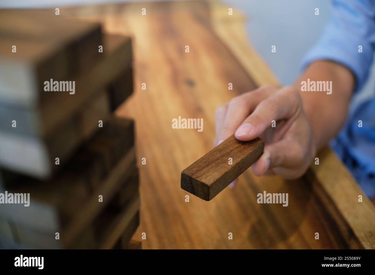 Gruppo di amici che gioca blocchi gioco di legno sul tavolo puzzle piegato Foto Stock