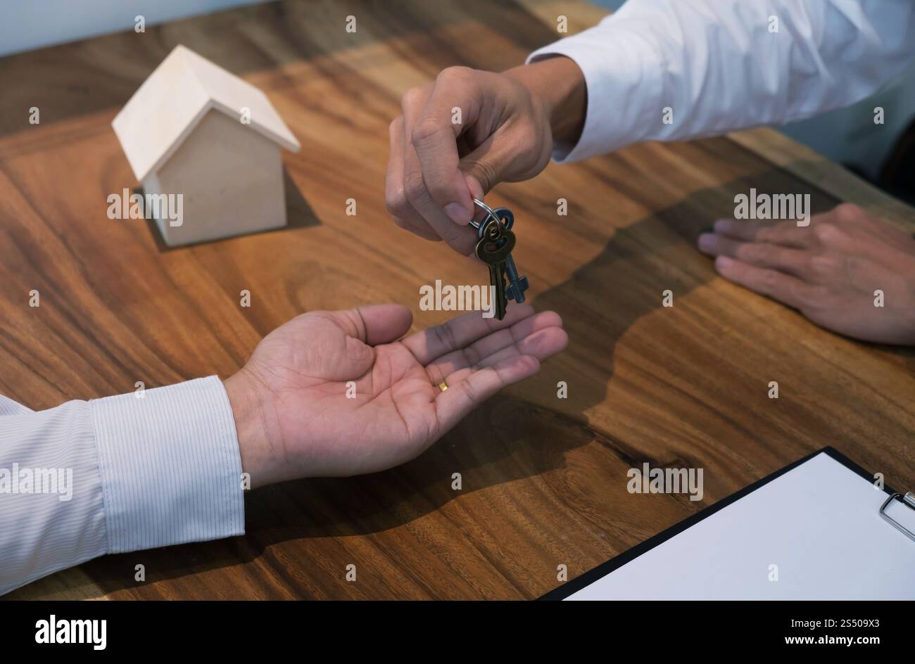 Agente immobiliare che dà le chiavi al cliente dopo la firma del contratto Foto Stock