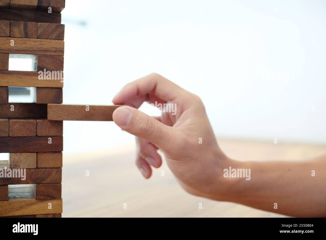 Gruppo di amici che gioca blocchi gioco di legno sul tavolo puzzle piegato Foto Stock