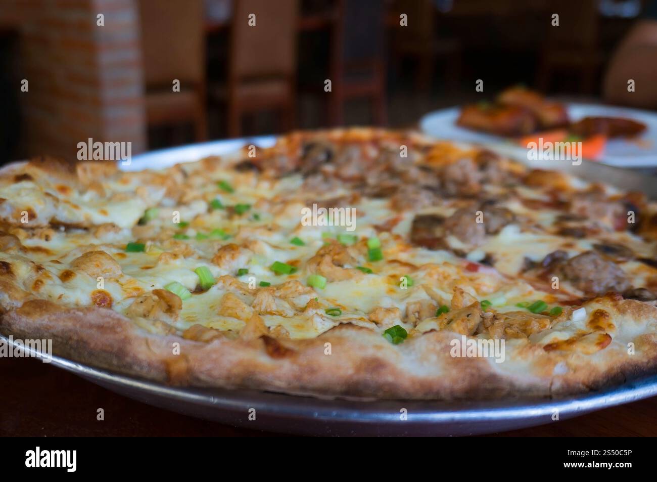 Pizza calda fatta in casa con formaggio fondente su un rustico tavolo di legno. Foto Stock