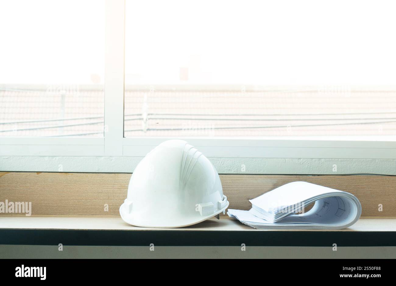 Progetti di disegno di costruzione e cappello bianco sul tavolo Foto Stock