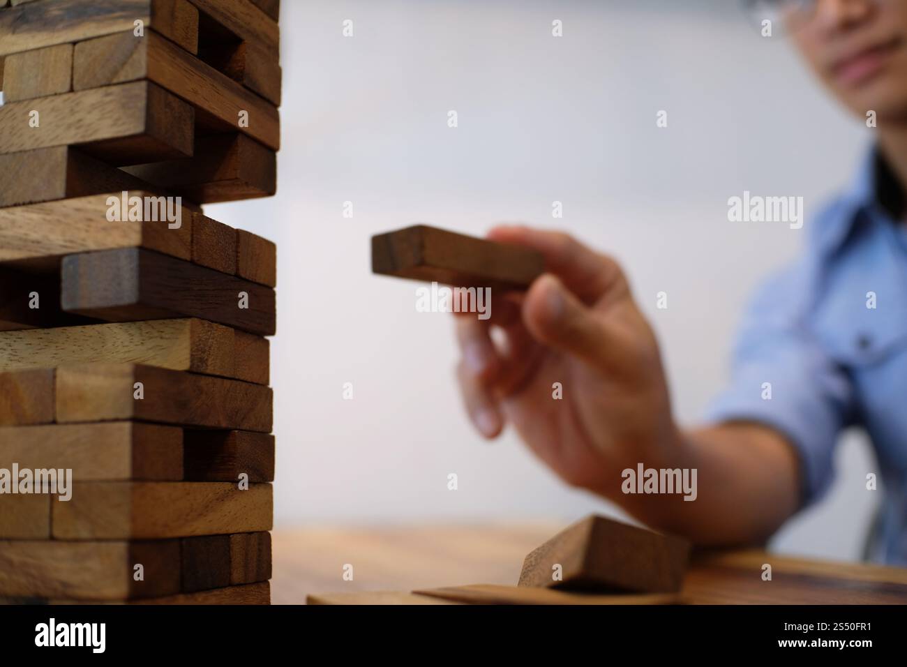 Gruppo di amici che gioca blocchi gioco di legno sul tavolo puzzle piegato Foto Stock