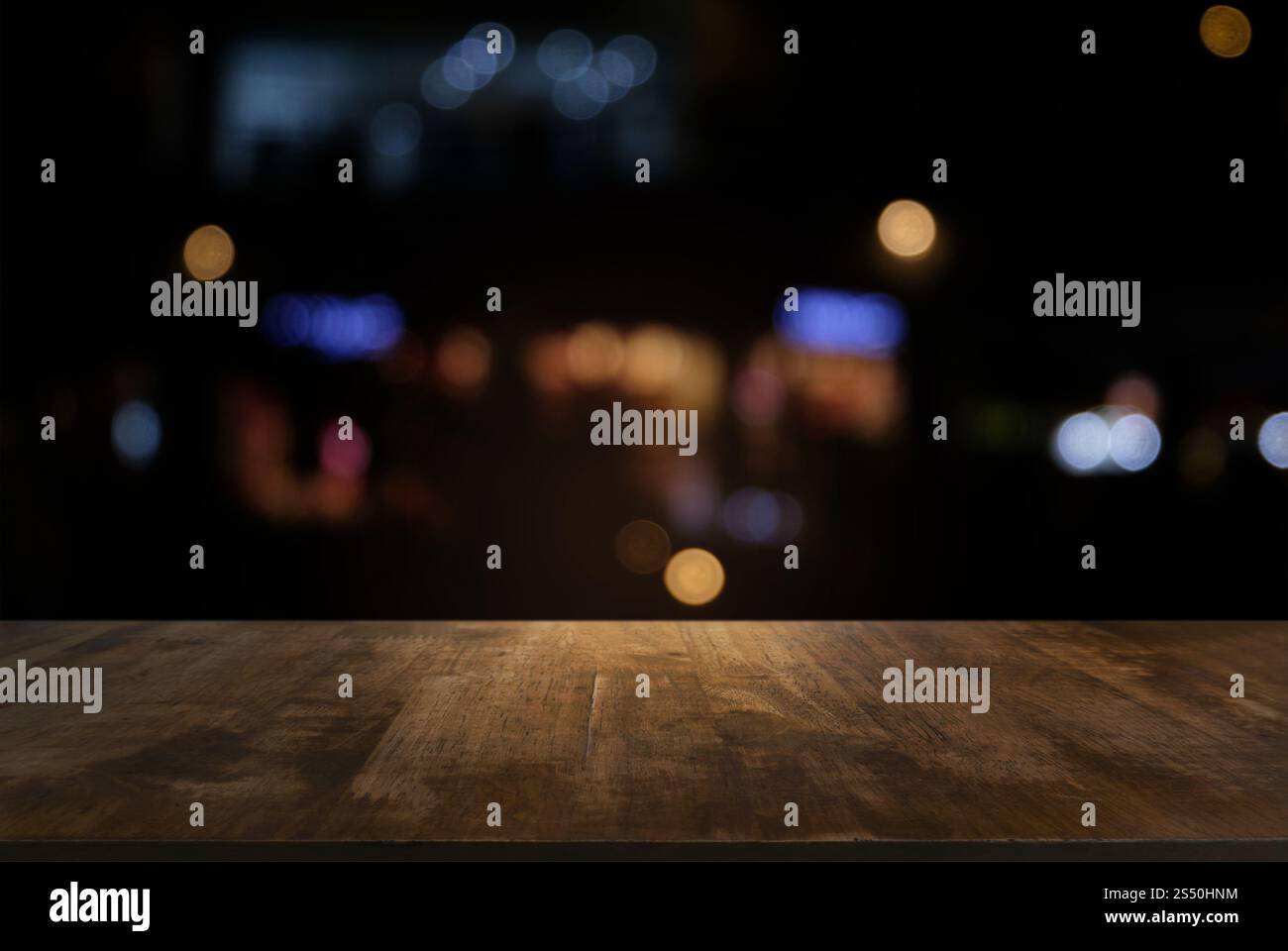 Tavolo vuoto di legno scuro davanti allo sfondo bokeh astratto e sfocato del ristorante. può essere utilizzato per la visualizzazione o il montaggio dei prodotti. Mock-up per Foto Stock