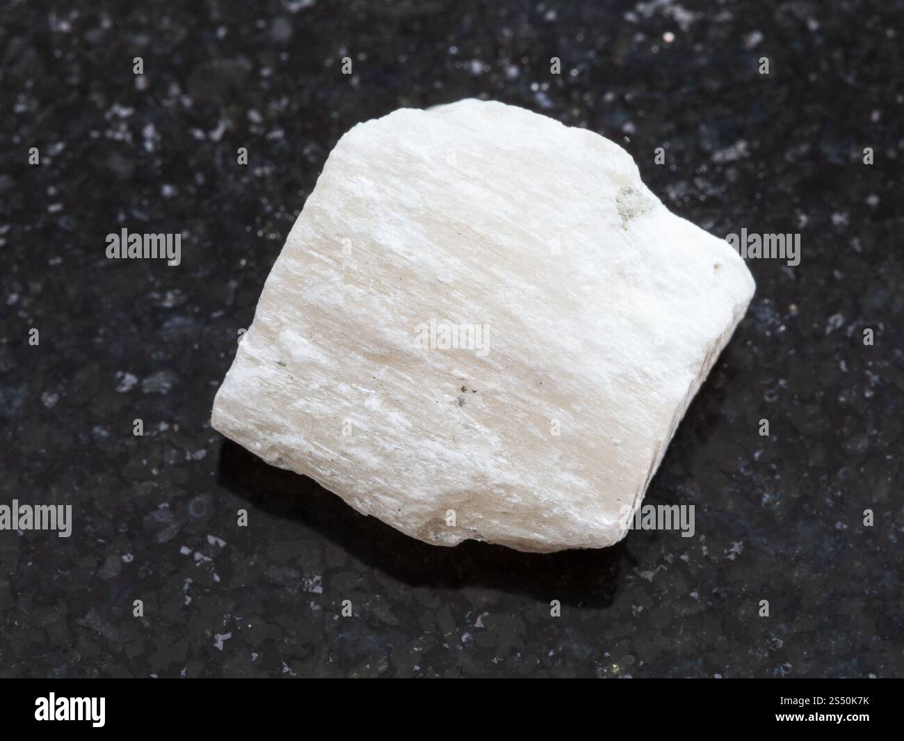 Le riprese in modalità macro di minerale naturale campione di roccia - gesso grezzo sulla pietra di granito scuro dello sfondo Foto Stock