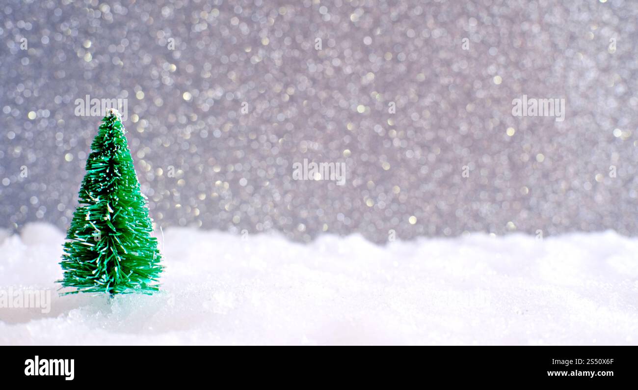Natale decorazione della casa con un piccolo dono fatti a mano box in una coperta di neve in miniatura della foresta sempreverde e bokeh luce per lo spazio di copia Foto Stock