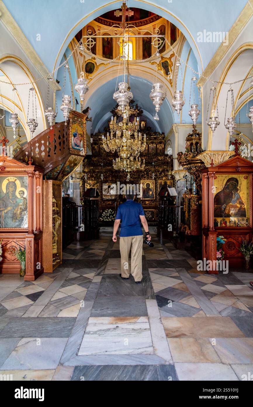 Interno della chiesa ortodossa decorata con iconografia religiosa e visitatrice, Mykonos, Grecia Foto Stock