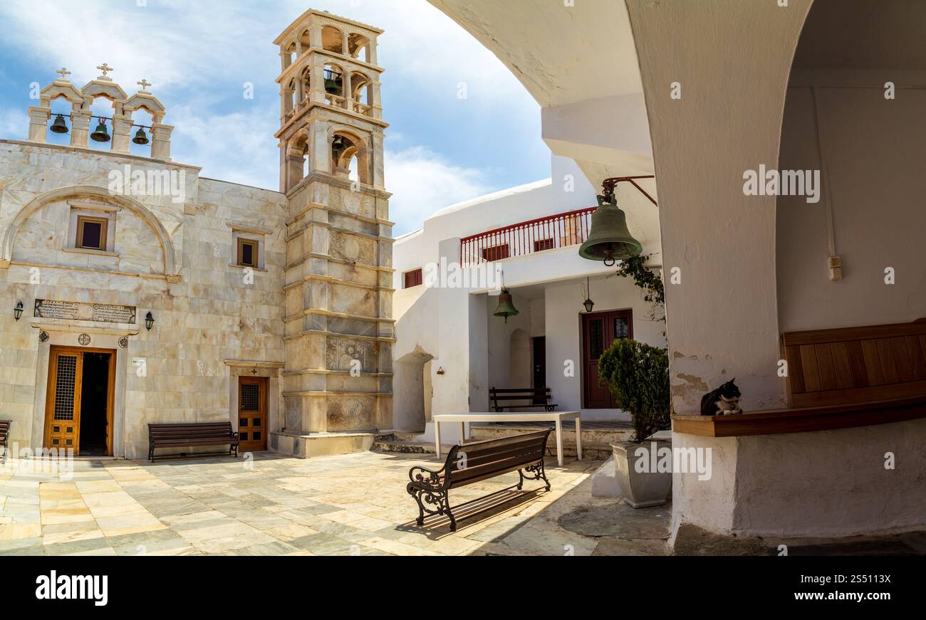 Cortile storico della Chiesa in pietra con Campane e panchine, Mykonos, Grecia Foto Stock