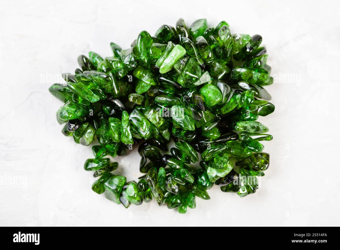 Stringa di perle naturali da cromo diopside cristalli sul cemento grigio sfondo Foto Stock