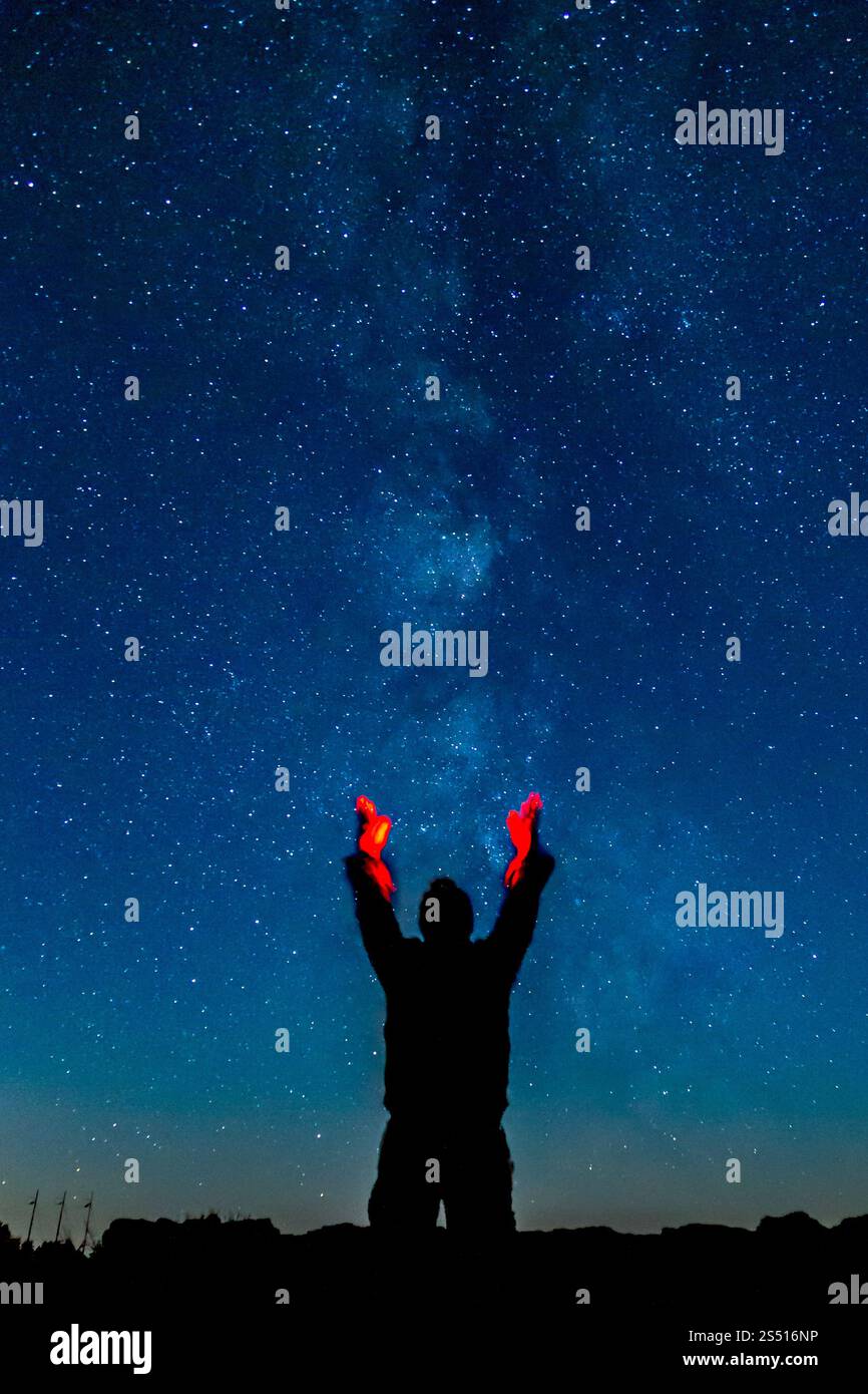 Silhouette di persona sotto un cielo stellato notturno con vivaci bastoncini luminosi, Cove Palisades, Oregon Foto Stock