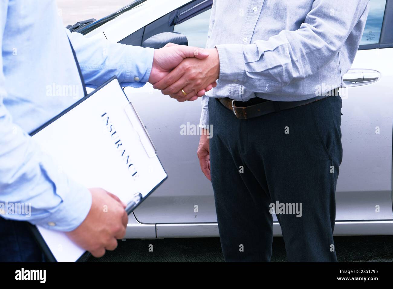 Handshake dell'agente di assicurazione del regolatore di perdita con l'ispezione dell'automobile danneggiata Foto Stock