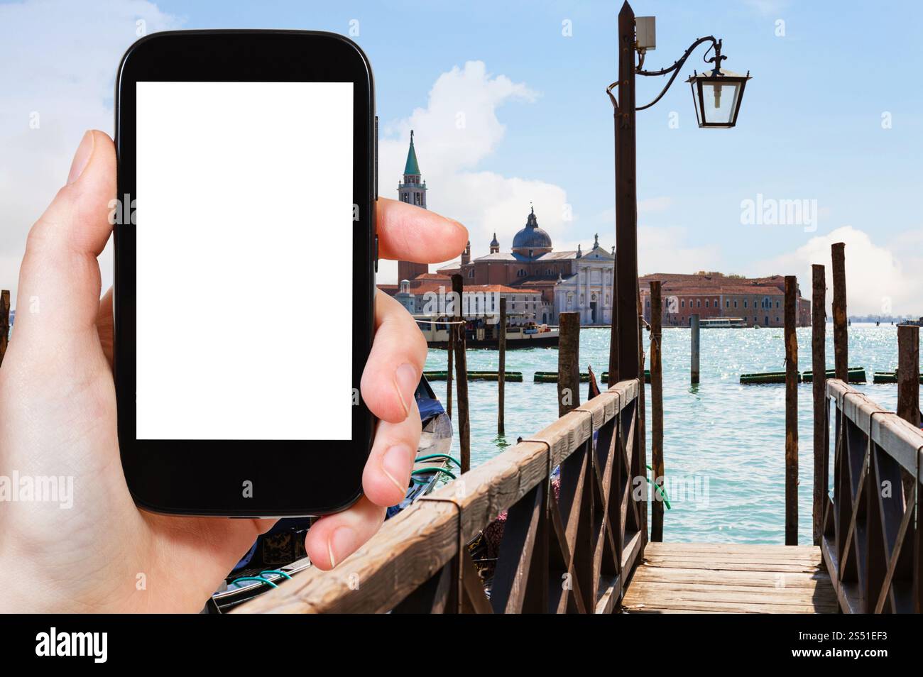 Concetto di viaggio - fotografie turistiche dell'isola di San Giorgio maggiore dal molo di Venezia in Italia in primavera su smartphone con schermo ritagliato per Foto Stock